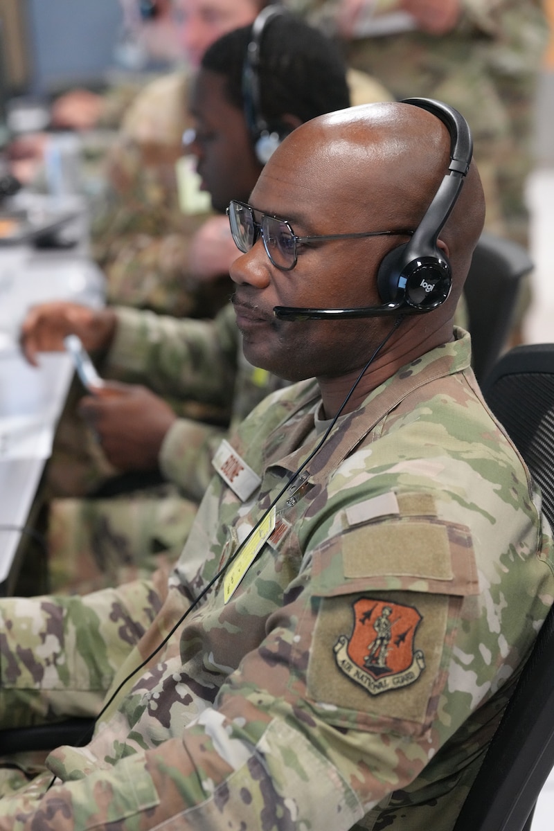 U.S. Airmen wearing headsets while working on computers