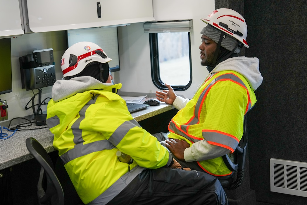 a woman and a man talk to one another while they sit next to each other