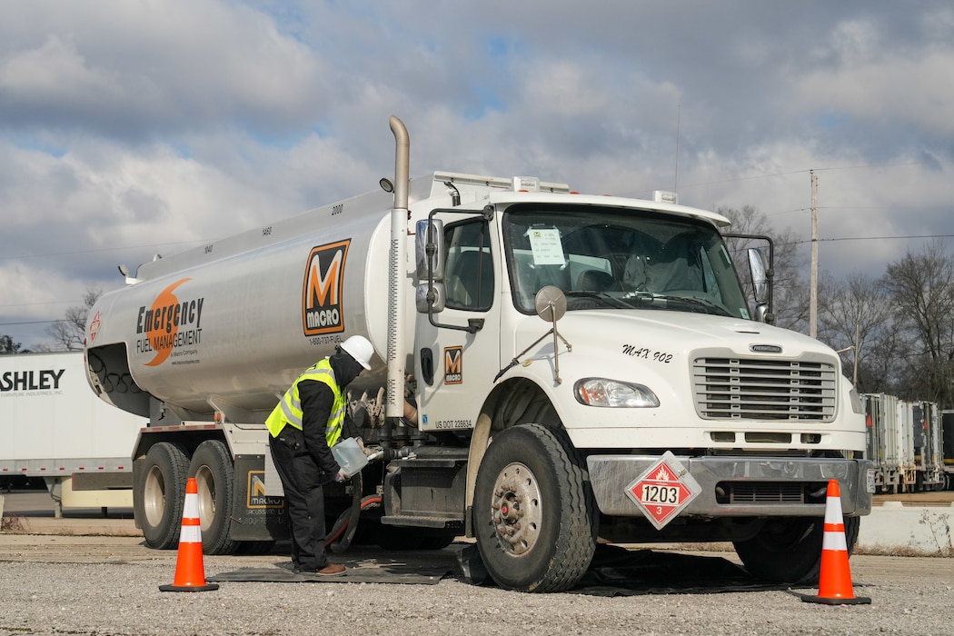 a man is next to a fuel truck