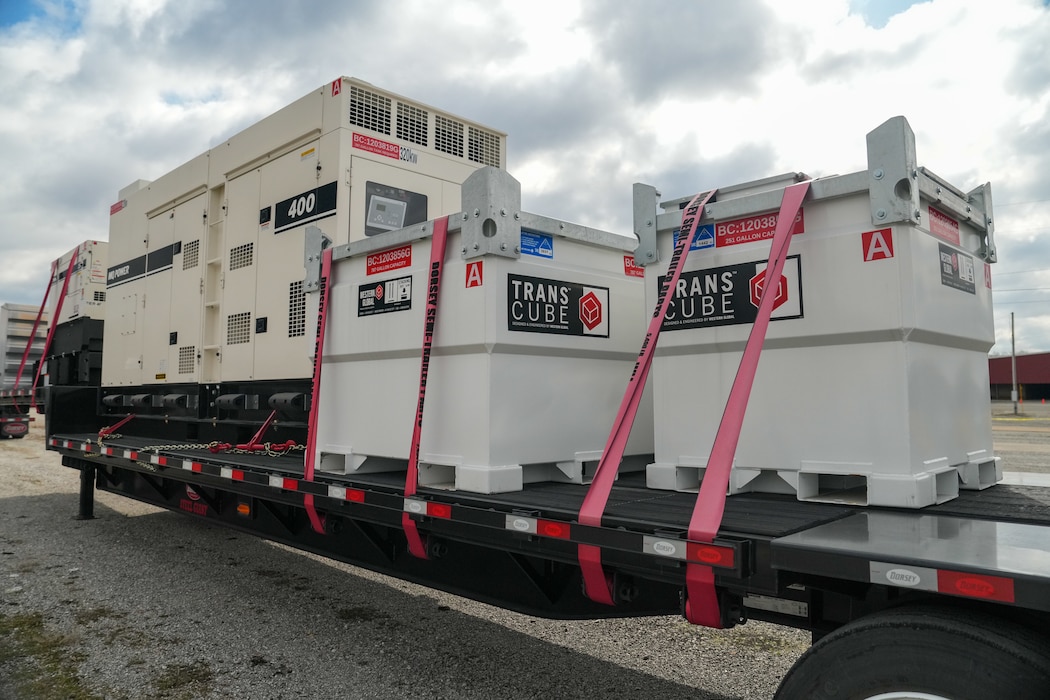 generators and external fuel tanks are strapped to a flatbed trailer