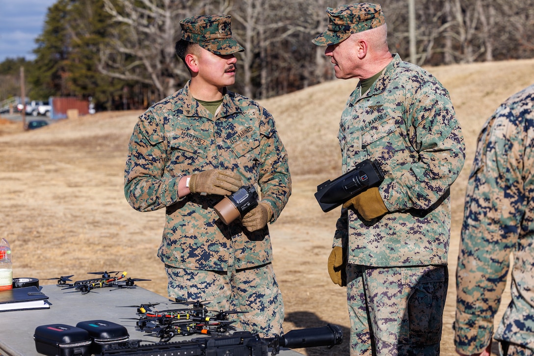 U.S. Marine Corps Lance Cpl. Bryen Z. Martinez, a military police officer with the Counter-Unmanned Aerial System’s Counter-Drone Team, left, explains equipment used for C-UAS to Col. Dennis W. Sampson, center, the Officer in Charge of Expeditionary Operations Training Group II Marine Expeditionary Force, during a C-UAS demo at The Basic School on Marine Corps Base Quantico, Virginia, Jan. 15, 2026. MCB Quantico’s Provost Marshal Office C-UAS Counter-Drone Team showcase tactics and technologies that counter aerial threats. (U.S. Marine Corps photo by Lance Cpl. Donovan E. Melendez)