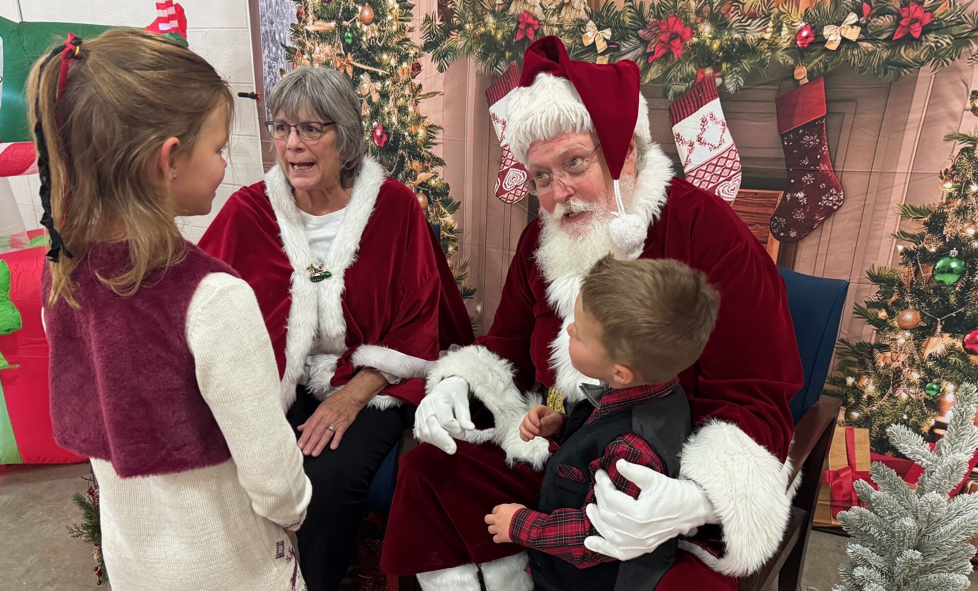 Santa and Mrs. Claus meet with children during a unit Christmas party.