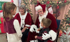 Santa and Mrs. Claus meet with children during a unit Christmas party.