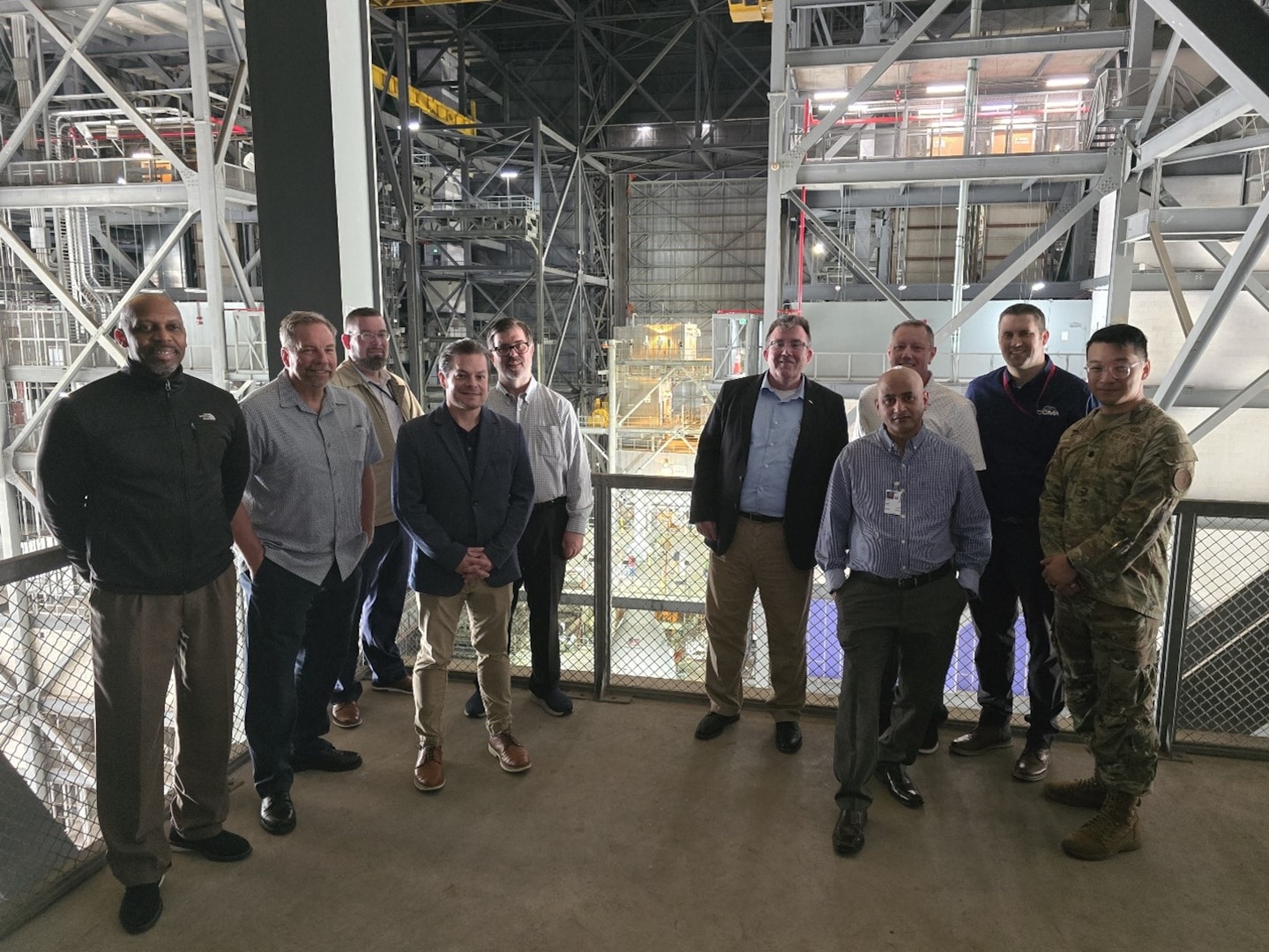 A group of men stand on a platform and pose for a photo