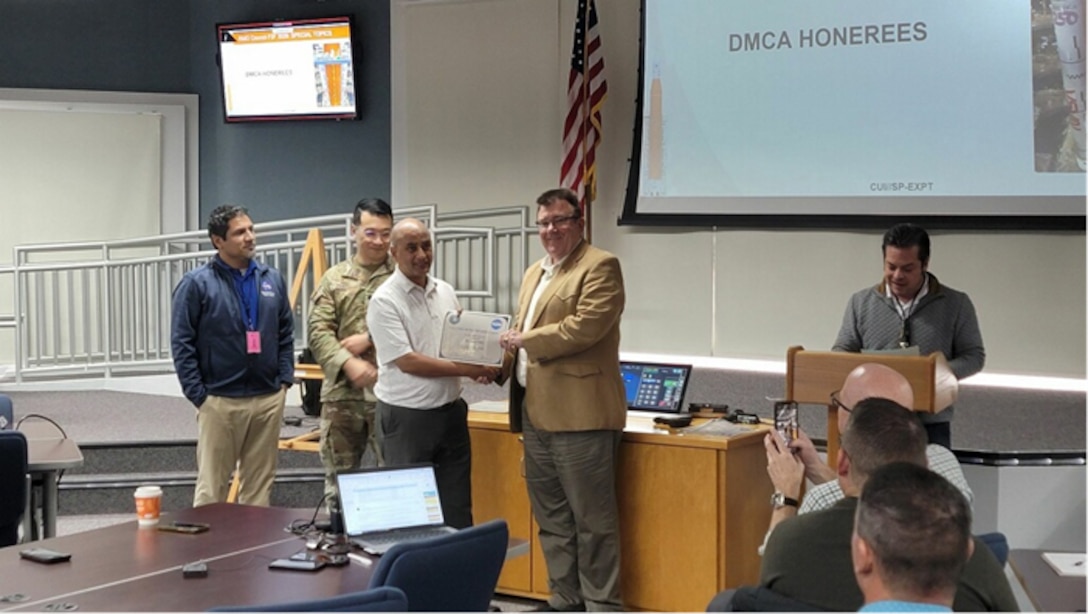 A man presents a certificate to another man