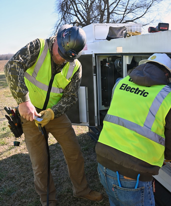 Two men are working on a generator