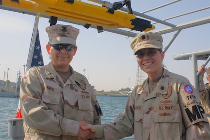 KUWAIT (2011) — Navy Cmdr. Karen Wingeart (right) reenlisted a Sailor aboard a security boat at a Kuwaiti Naval Base in 2011 while recalled to active duty from the Navy Reserve. Wingeart coordinated the at-sea re-enlistment with a Coast Security Detachment during a desert-based deployment, allowing Sailors assigned to the Theater Field Confinement Facility to briefly return to the water.