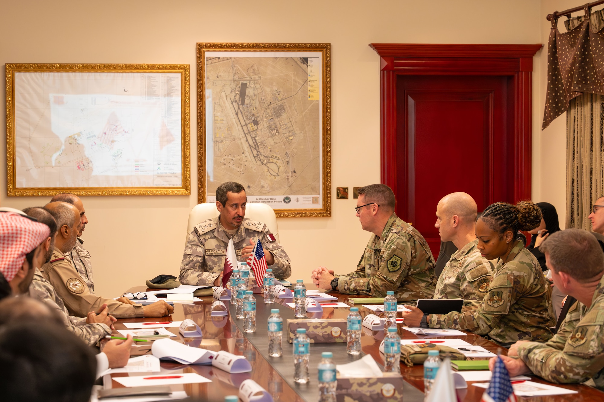 People sit on each side of a long wood table with one member at the head of the table