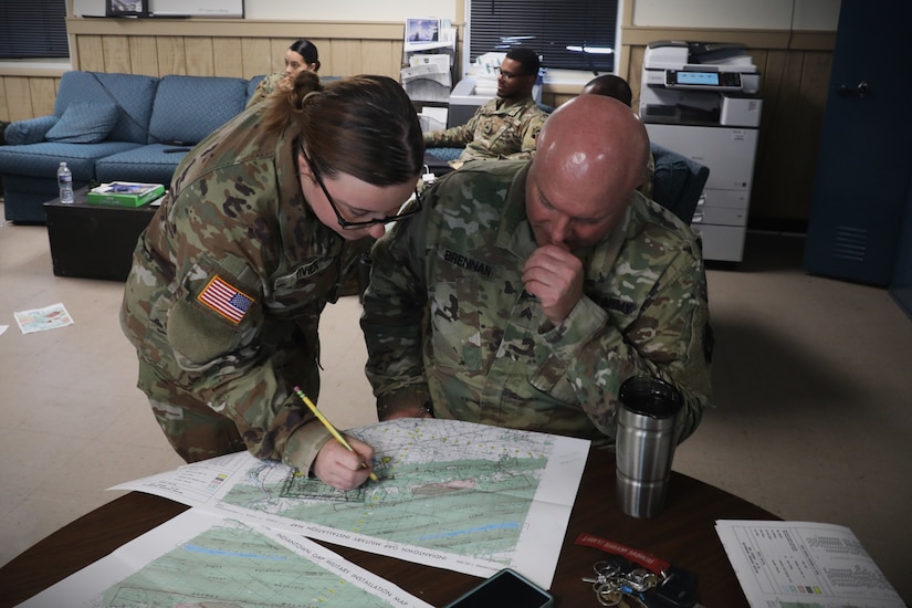 U.S. Army Spc. Aliyah Vivier left and Sgt. Glenn Brennan, public affairs specialists assigned to the 109th Mobile Public Affairs Detachment, 213th Regional Support Group, Pennsylvania National Guard, look over a map during a land navigation refresher course at Fort Indiantown Gap, Pennsylvania, July 16, 2025.  Land navigation is a fundamental military skill that involves using a map, compass, and terrain to navigate to specific locations. (U.S. Army National Guard photo by Spc. Skylin Simpson)