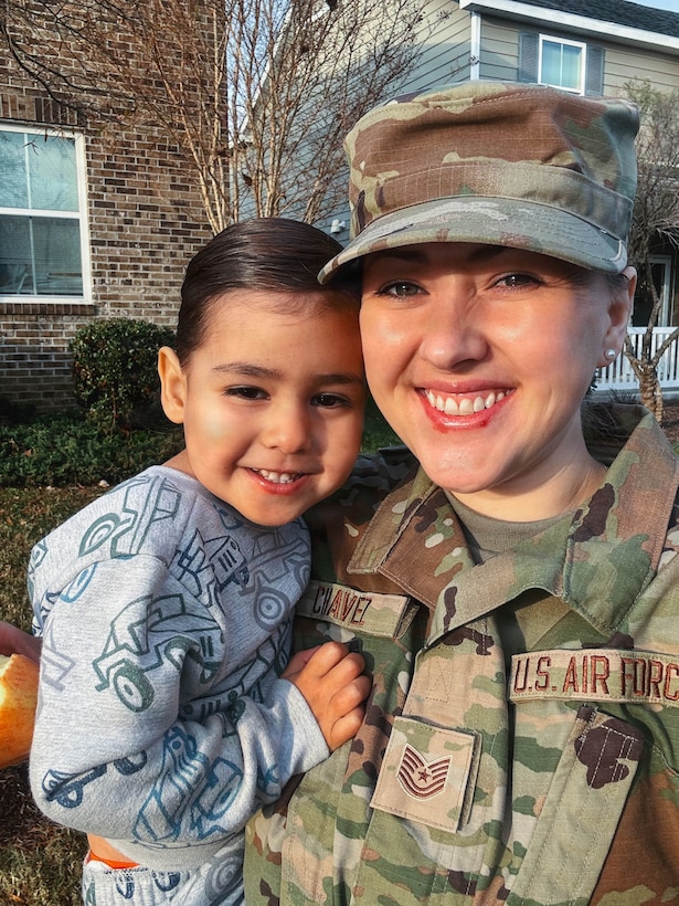 A U.S. Airman holds her young son.
