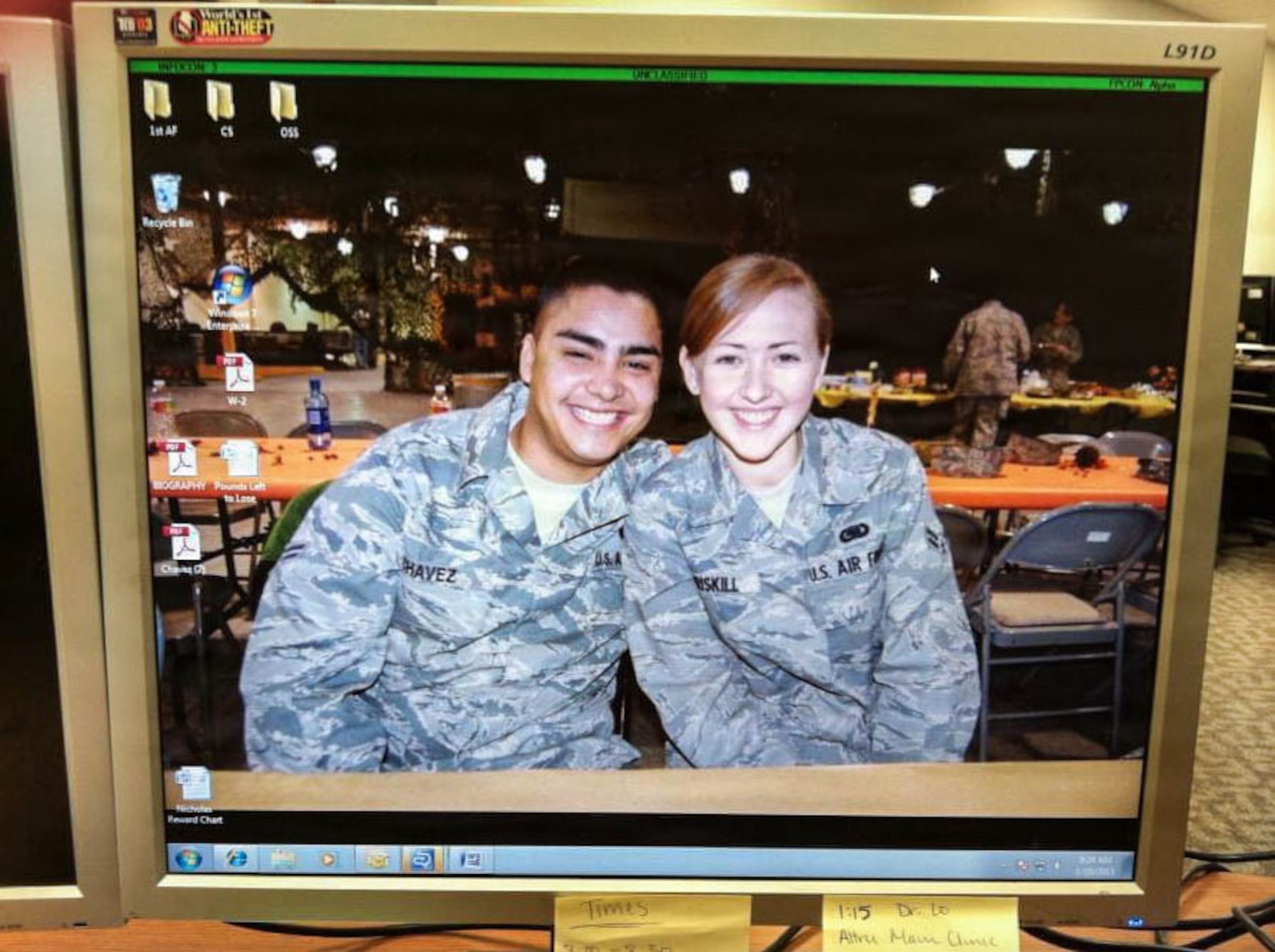 Two U.S. Airmen sit next two each other at a table.
