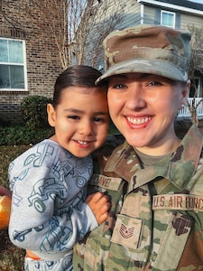 U.S. Airman holds her young son in her arms.