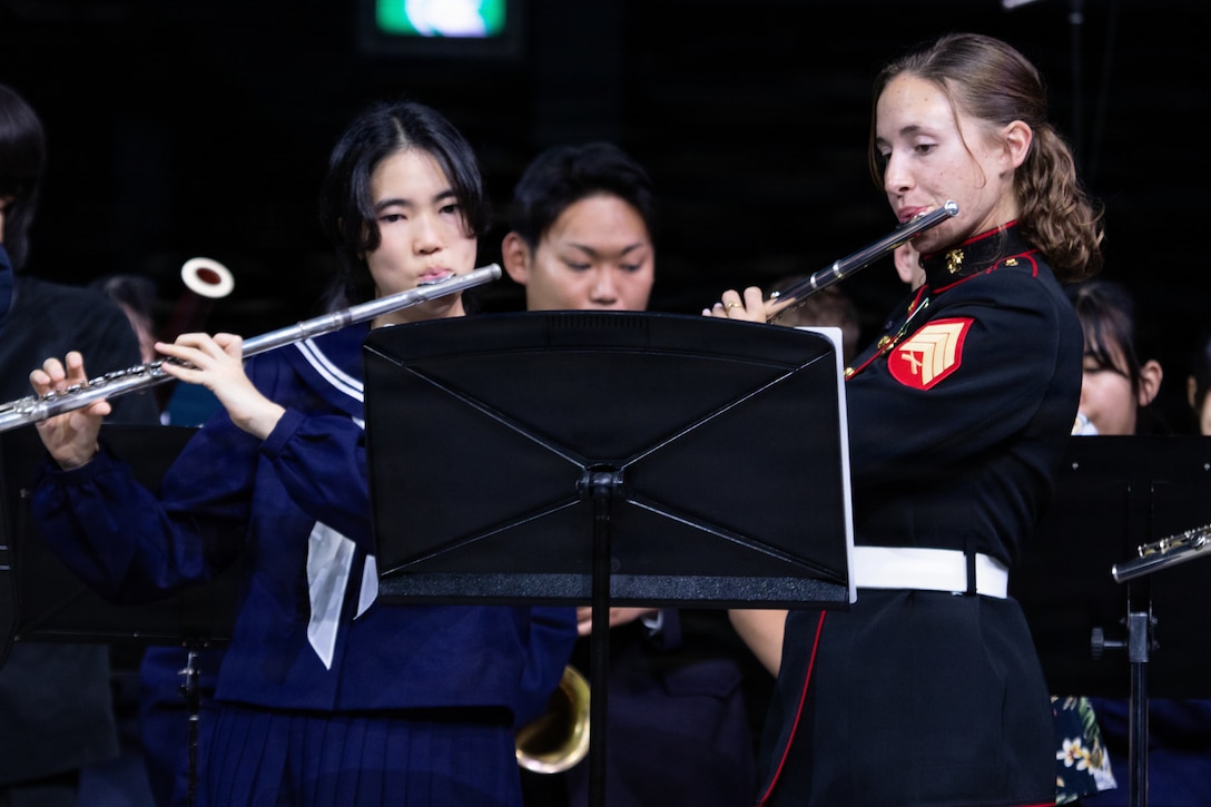 U.S. Marine Sgt. Paige Brokopp (right), a flute player with the III Marine Expeditionary Force Band, performs alongside a student from Yomitan High School during the Japan – U.S. Joint Concert, Jan. 17, 2026, at the Okinawa SUNTORY Arena, Okinawa, Japan. The event was hosted by the Okinawa Defense Bureau, Ministry of Defense, and featured performances from local middle schools, the Japan Ground Self-Defense Force 15th Brigade Band, and the Japan Air Self-Defense Force Southwestern Band. The Marines performed alongside the attending bands to build and strengthen their relationships with the local community and their partner organizations. Brokopp is a native of Florida. (U.S. Marine Corps photo by Staff Sgt. Shannon Doherty)