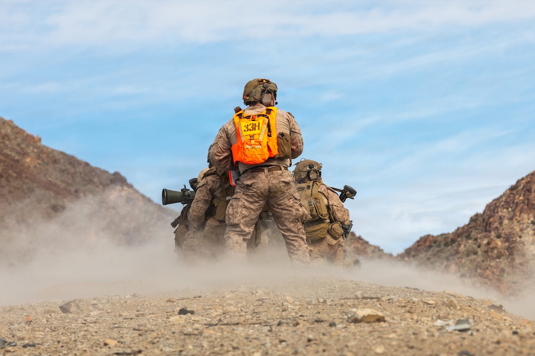 A U.S. Marine with Tactical Training and Exercise Control Group, Marine Air-Ground Task Force Training Command, Marine Corps Air-Ground Combat Center, observes Marines with Kilo Company, 3rd Battalion, 7th Marine Regiment, 1st Marine Division, fire an M3A1 multi-role anti-armor anti-personnel weapon system during a service level training exercise at Marine Corps Air-Ground Combat Center, Twentynine Palms, California, Jan. 26, 2026. SLTE is designed to be a challenging, realistic training environment that produces combat-ready forces capable of operating as an integrated Marine Air-Ground Task Force across all domains of military operations. (U.S. Marine Corps photo by Cpl. Keegan Jones)