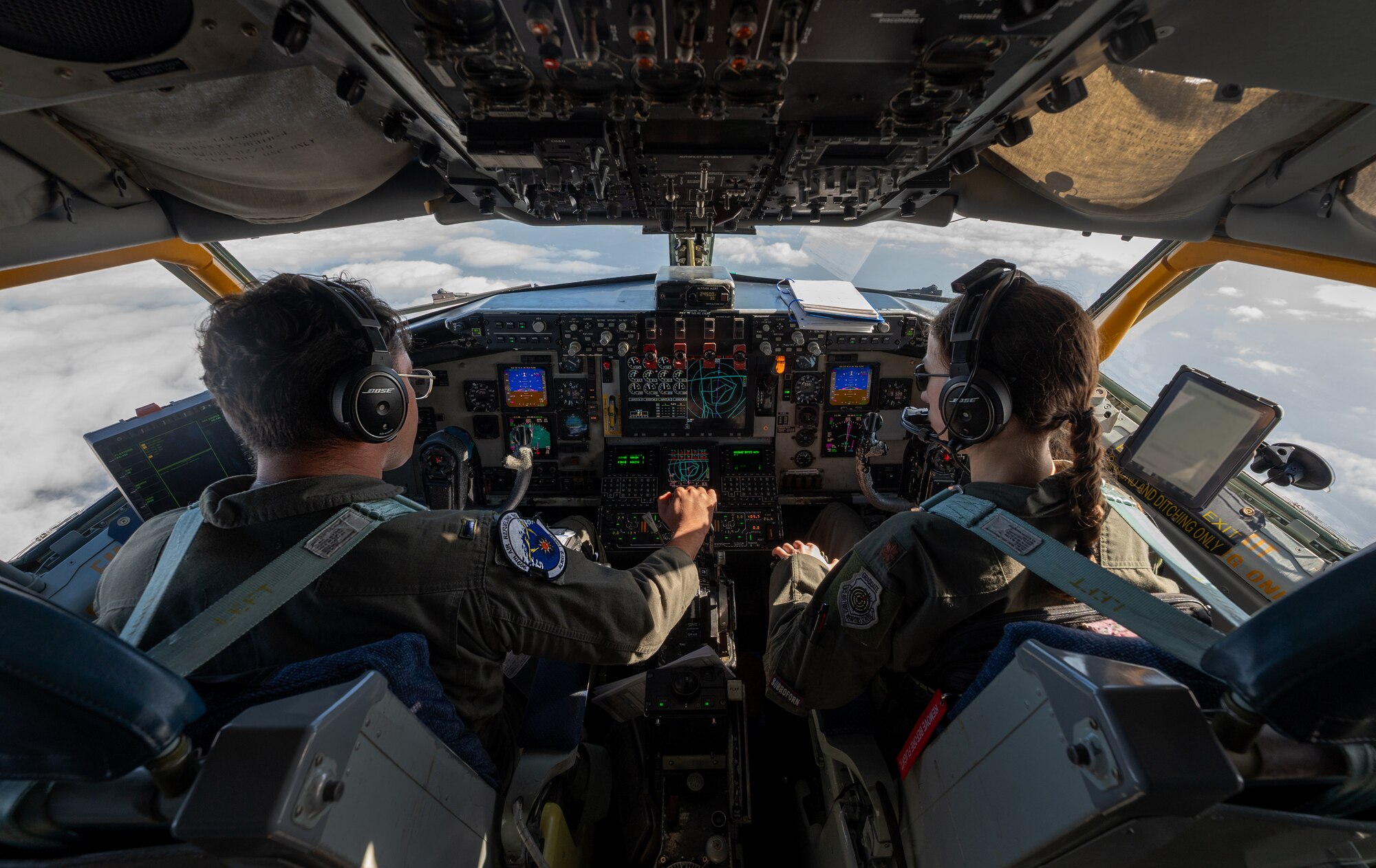 U.S. Air Force Maj. Caroline Bates, right, 909th Air Refueling Squadron KC-135 instructor pilot, and 1st Lt. Ghamanpreet Ahluwalia, 909th ARS KC-135 Stratotanker pilot, fly a KC-135 over the Pacific Ocean.