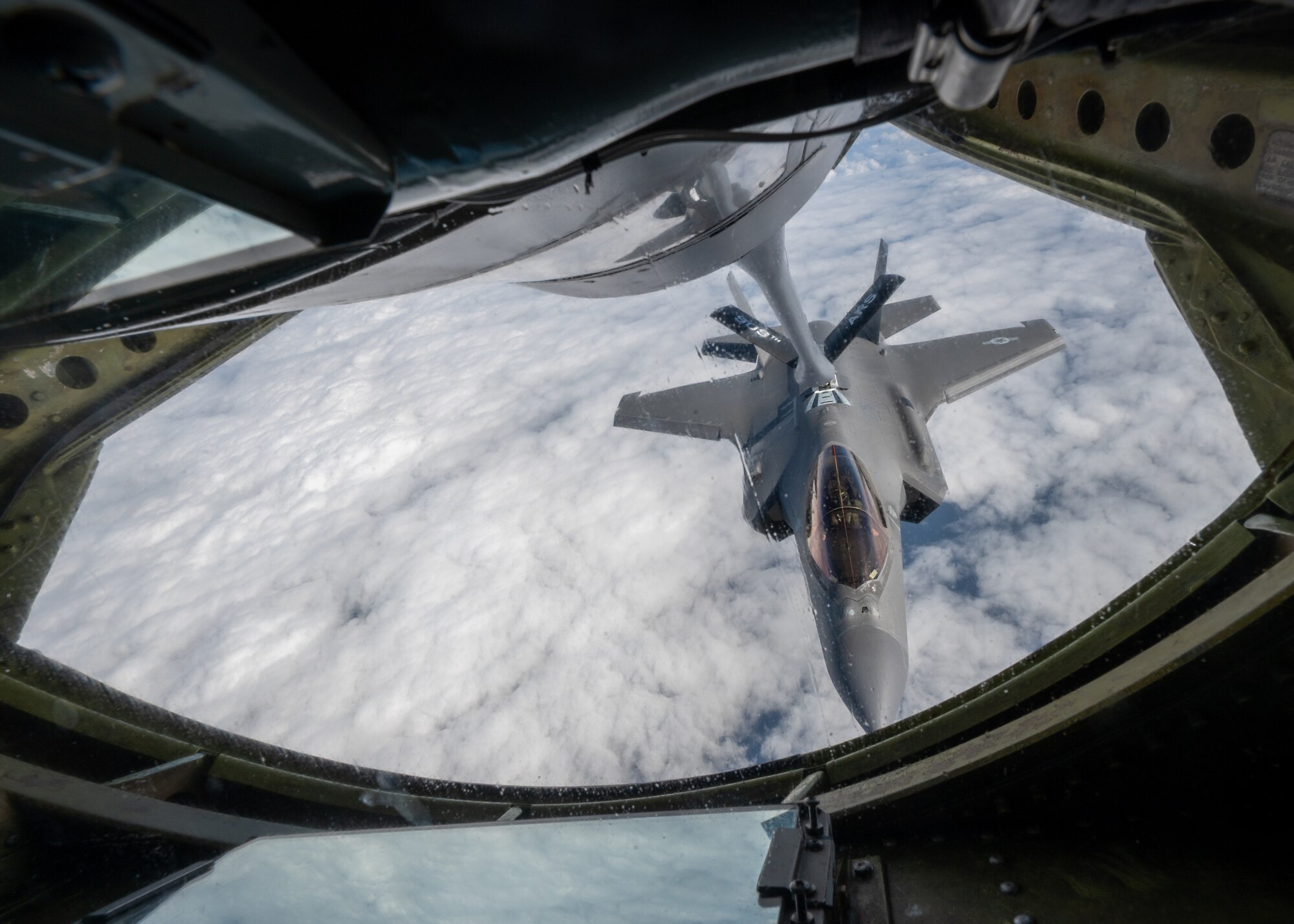 A U.S. Air Force F-35A Lightning II assigned to the 4th Expeditionary Fighter Squadron, deployed to Kadena Air Base, conducts aerial refueling operations with a KC-135 Stratotanker assigned to the 909th Air Refueling Squadron over the Pacific Ocean.