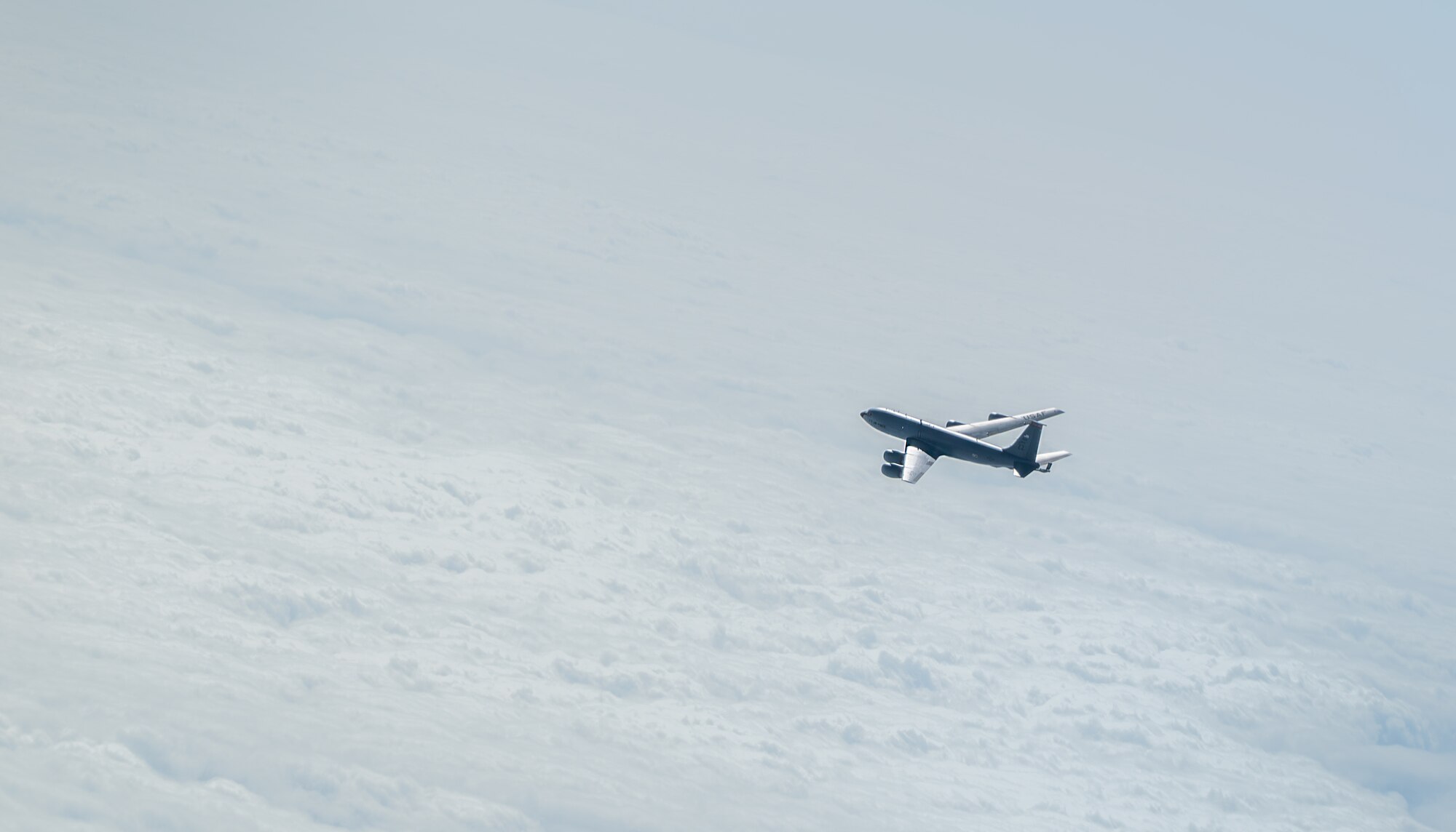 A U.S. Air Force KC-135 Stratotanker from the 909th Air Refueling Squadron, flies over the Pacific Ocean.