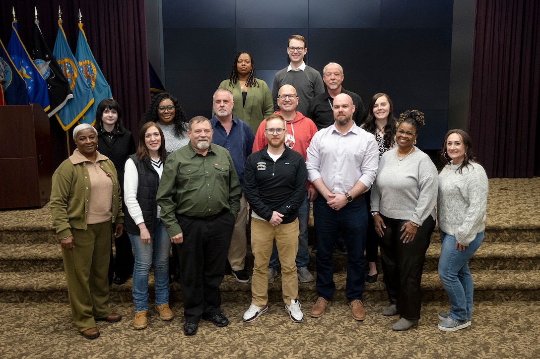 Group photo of 15 people inside conference room