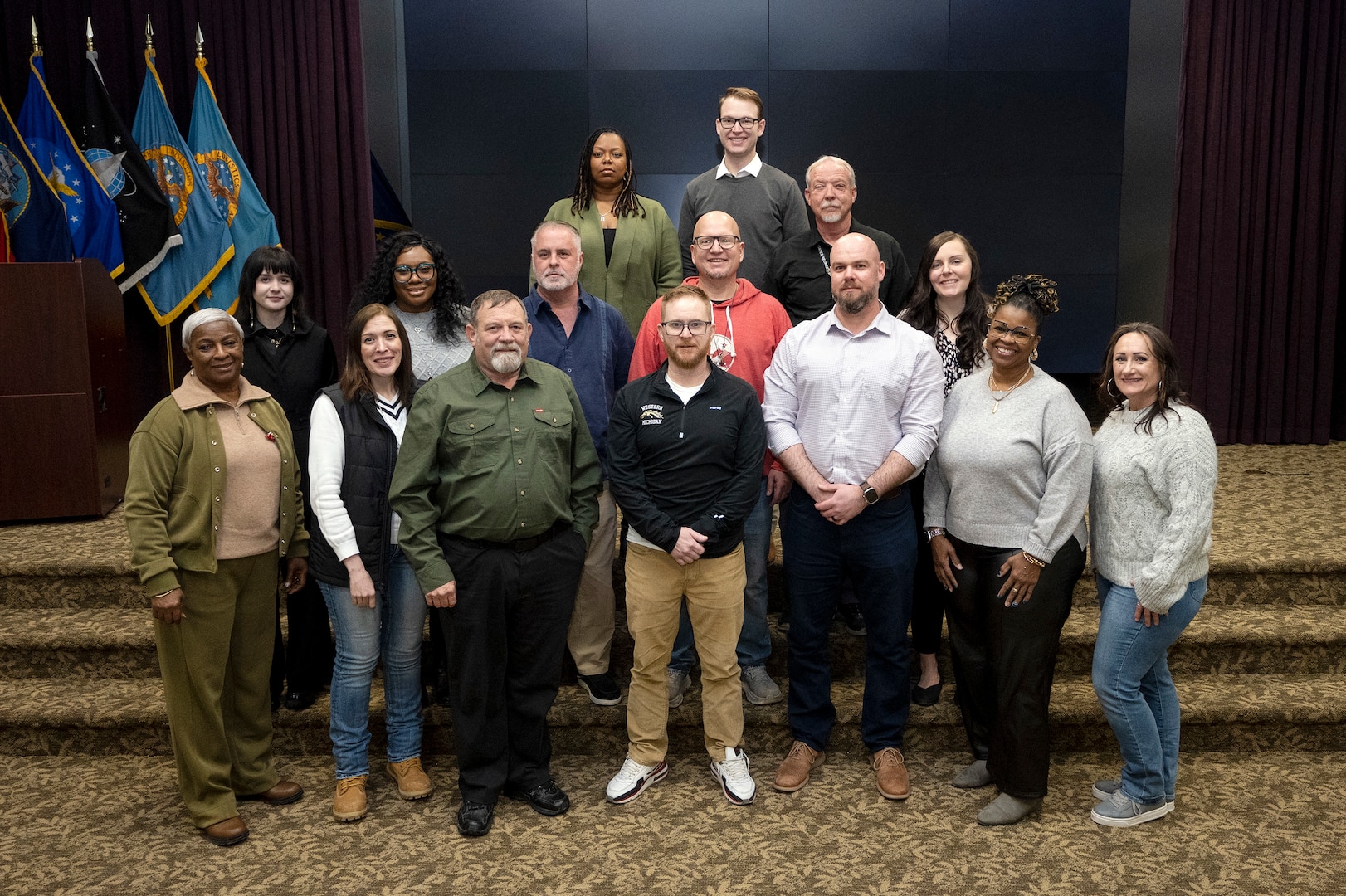 Group photo of 15 people inside conference room