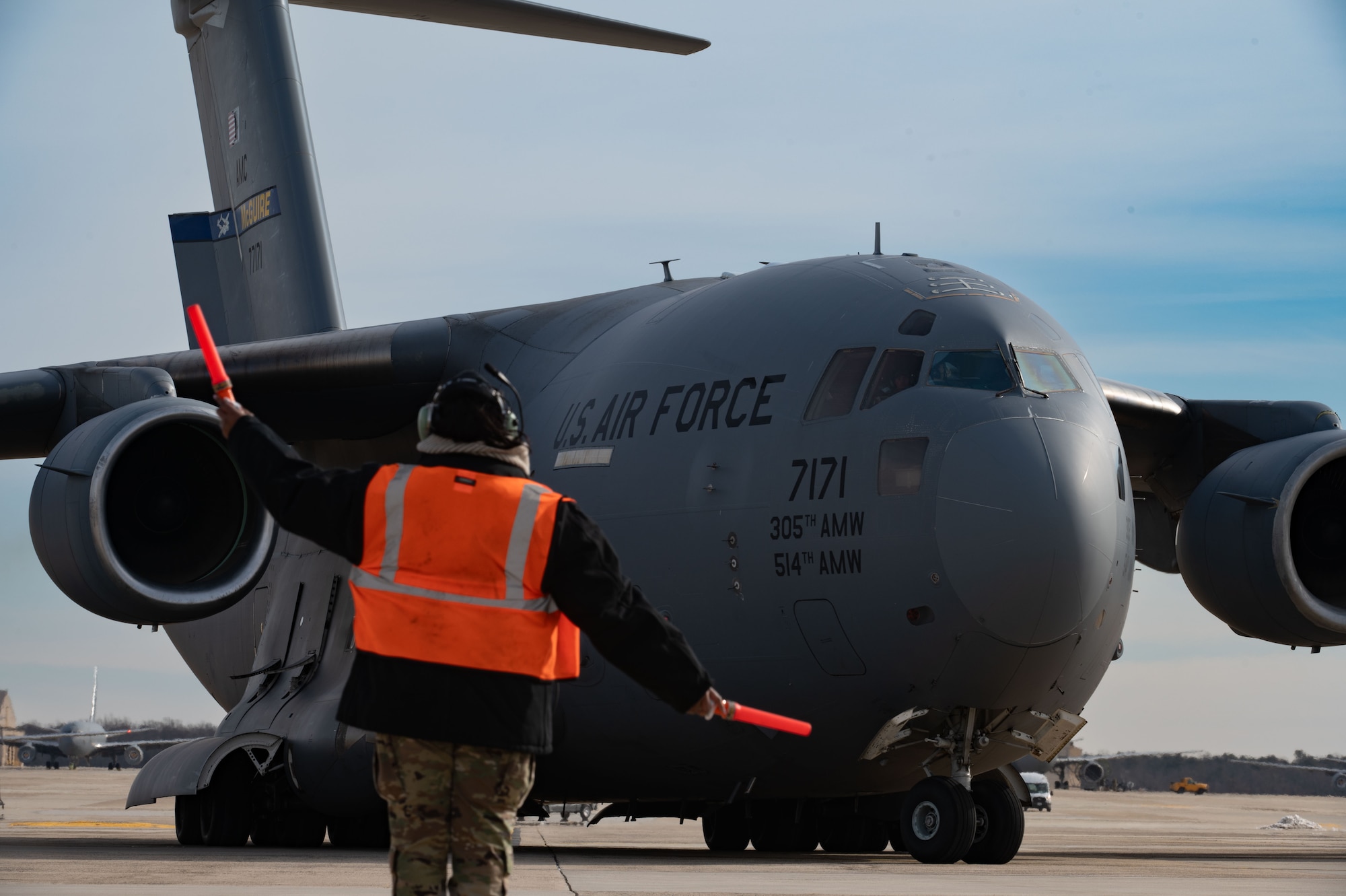 A U.S. Air Force crew chief marshals a C-17 Globemaster III cargo aircraft assigned to
the 305th Air Mobility Wing, as it taxis on the flight line at Joint Base McGuire-Dix-
Lakehurst, N.J., Jan. 24, 2026. Aircrew assigned to the 305th AMW worked to
reposition multiple aircraft from JB MDL to ensure continued mission support, despite
Winter Storm Fern. (U.S. Air Force photo by Airman 1st Class Haeleigh Bayle)