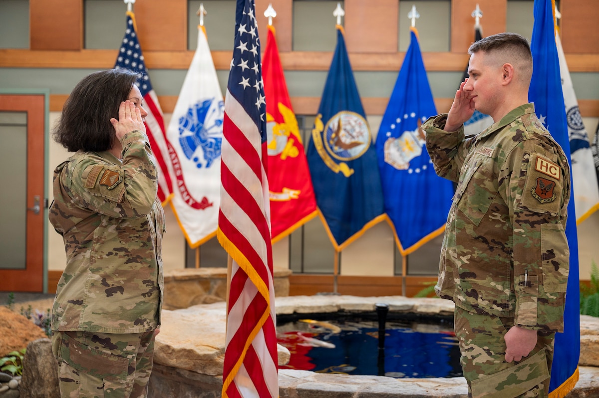 U.S. Air Force Col. Martha Sasnett, Air Force Mortuary Affairs Operations commander and 2nd Lt. Christopher Browning, a reserve chaplain candidate, salute after a coin presentation at Dover Air Force Base, Delaware,  Jan. 29, 2026. After a short tour at AFMAO, 2nd Lt. Browning is now going through the process of finalizing documentation and working with a recruiter to find a gaining base until finally recommissioning as a fully qualified Air Force Chaplain. (U.S. Air Force photo by Staff Sgt. Frank Rohrig)