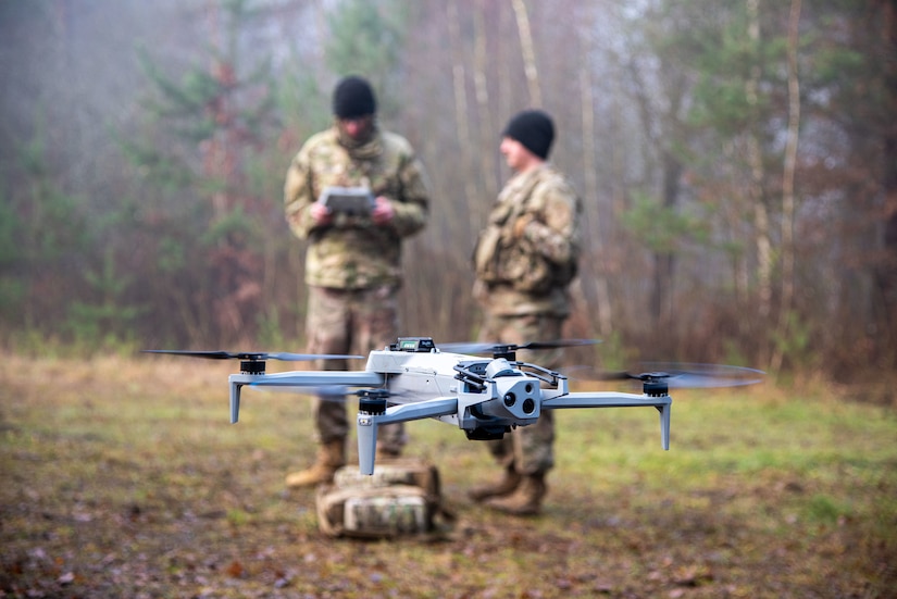 U.S. Army Sgt. Anthony Karl (left) and Staff Sgt. Jacob Owens, assigned to the 1st Engineer Battalion, 1st Brigade Combat Team, 1st Infantry Division, test fly the Skydio X10 during the U.S. Army Europe and Africa Best Drone Warfighter Competition in the Grafenwoehr Training Area, Germany, Dec. 10, 2025. The competition assesses unmanned aerial systems operator capabilities from the U.S., Spain and Italy, and reinforces the U.S. Army's commitment to innovation and readiness, and builds esprit des corps and camaraderie. (U.S. Army photo by Sgt. Collin Mackall)