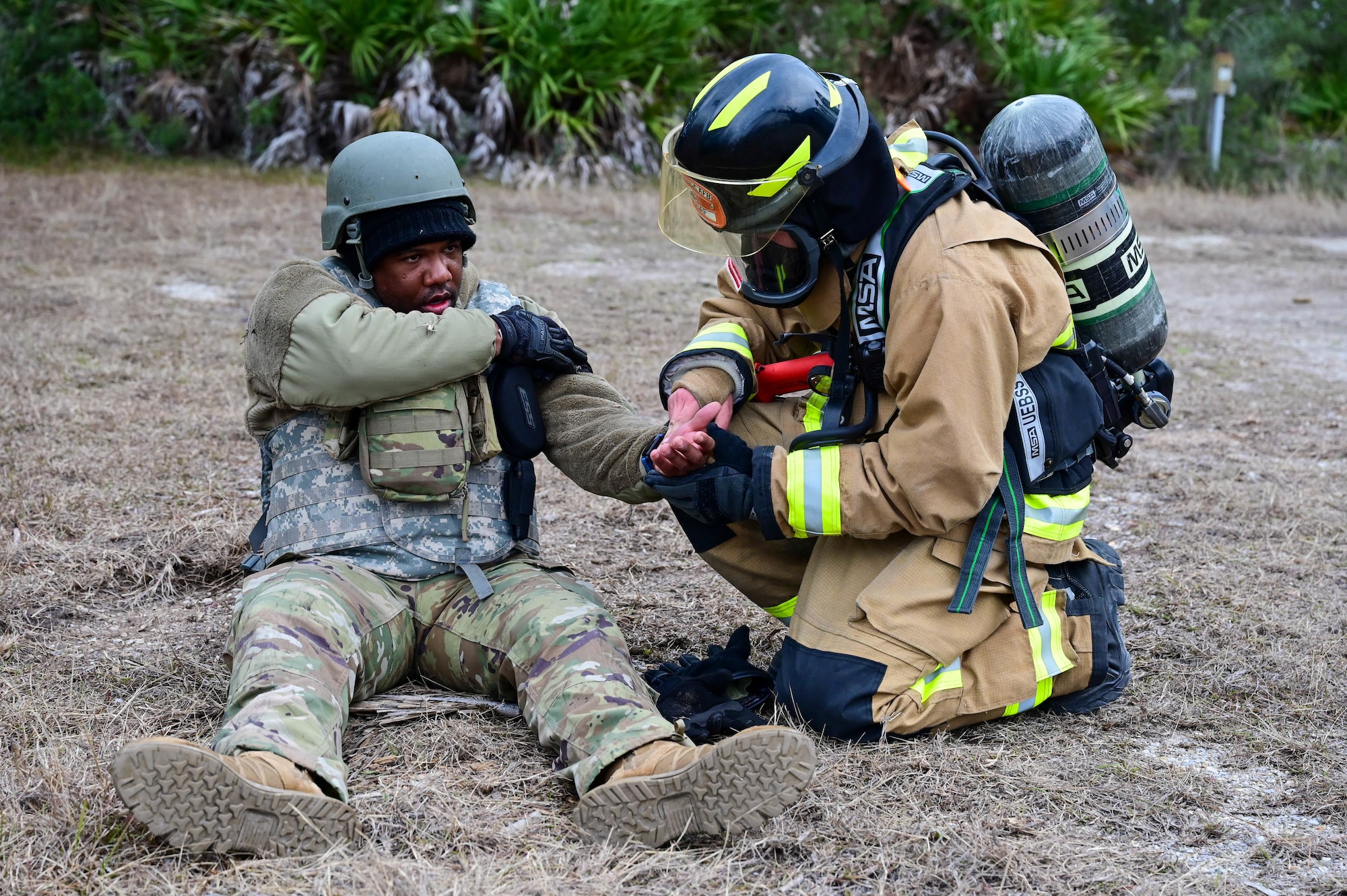 A firefighter tends to an injured Airman.