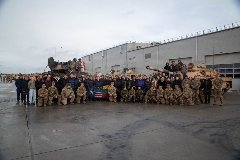 U.S. Army Soldiers and NATO Allies take a group photo with Lithuanian high schoolers, Dec. 10, 2025, on General Silvestras Žukauskas Training Area, Pabradė, Lithuania. U.S Army Soldiers partnered with NATO Allies to conduct the NATO Force Integration School Project, a community relations program that allowed the community to understand the U.S. Army's role in Lithuania. (U.S Army photo by Spc. Kemarvo Smith)