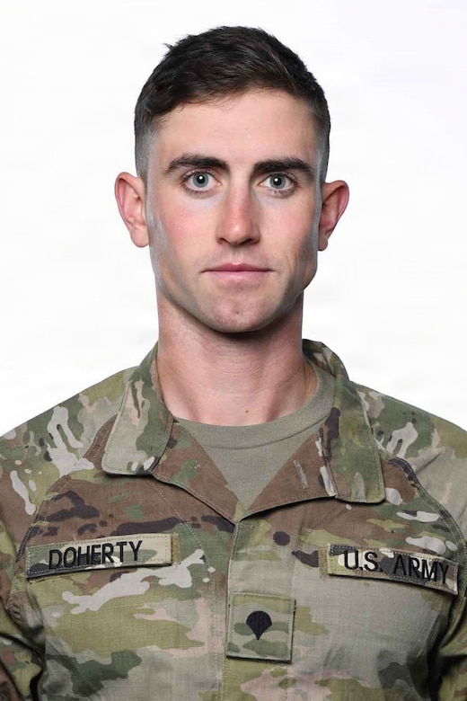 A man wearing a camouflage military uniform poses for a photo.