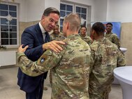 NATO Secretary General Mark Rutte shakes hands with U.S. Army Lt. Col. John Nimmons during a holiday dinner at Bemowo Piskie Training Area, Poland, Dec. 18, 2025. The engagement allowed Allied leaders to thank forward-deployed service members and recognize their role in supporting NATO’s mission. Senior NATO and Allied leader engagements demonstrate continued support for Soldiers serving their countries and the Alliance during the holiday period. (U.S. Army photo by Sgt. Eric Allen)
