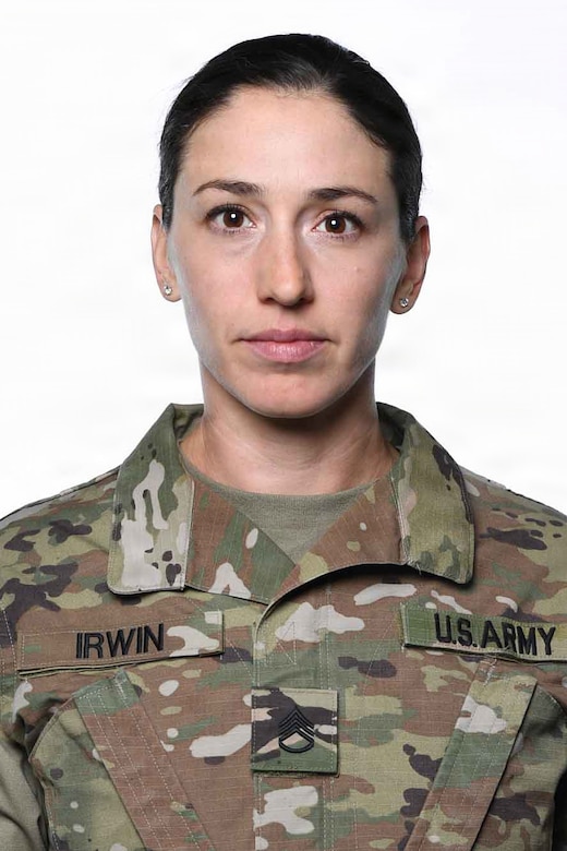 A woman wearing a camouflage military uniform poses for a photo.