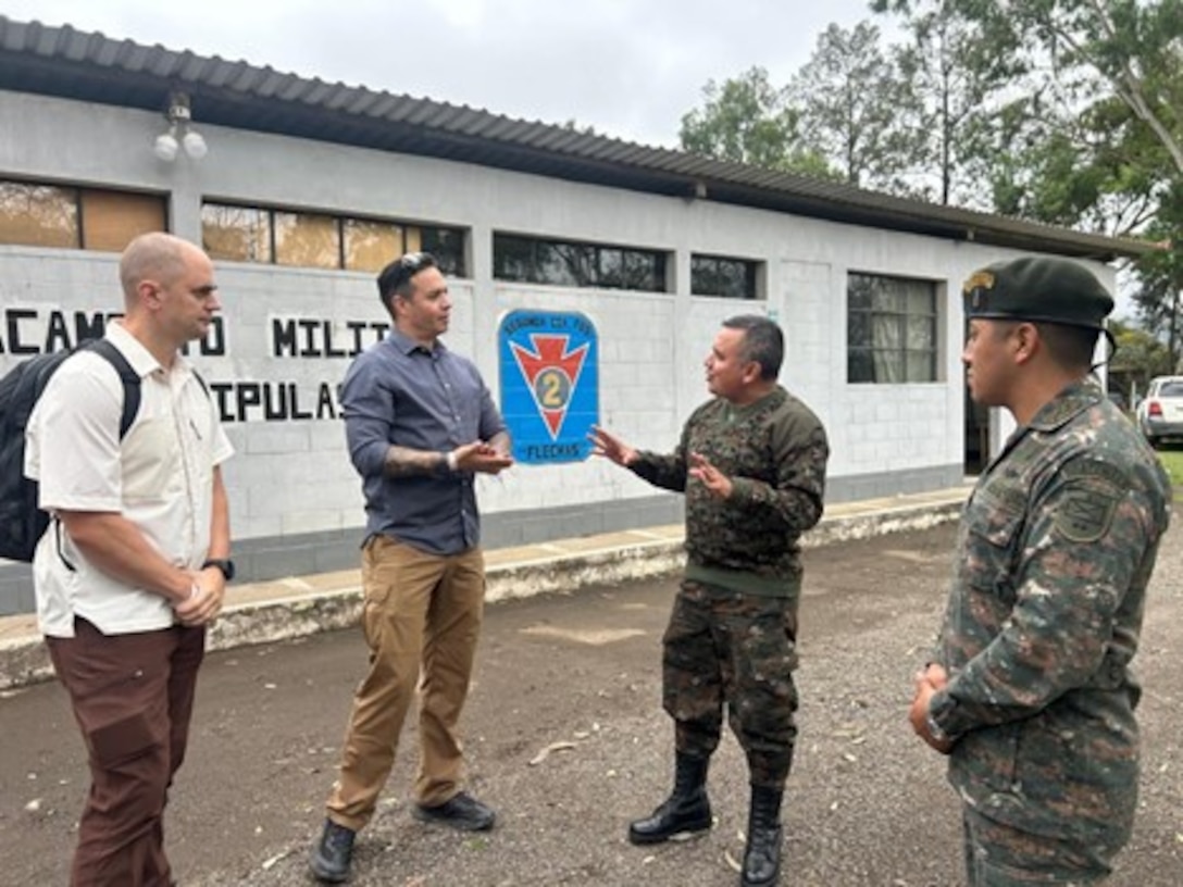 U.S. Soldiers and Guatemalan land forces talk to one another.
