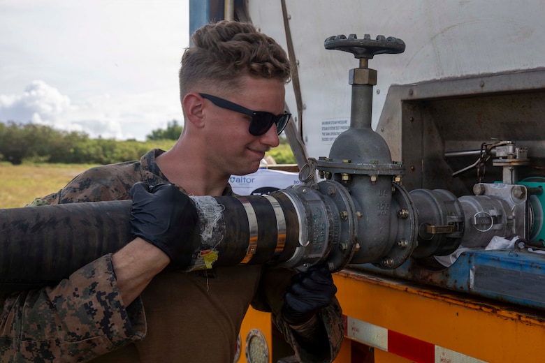 U.S. Marine Corps Lance Cpl. Robert Byers, an expeditionary fuels technician with Marine Wing Support Squadron 171, Marine Aircraft Group 12, 1st Marine Aircraft Wing, attaches a fuel hose to a fuel truck during an Aviation Training Relocation program at Tinian, Northern Mariana Islands, January 16, 2026.