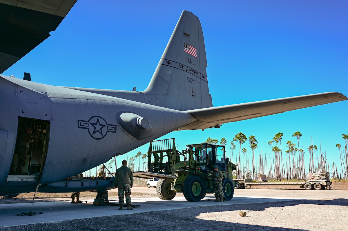 People load equipment into a plane.
