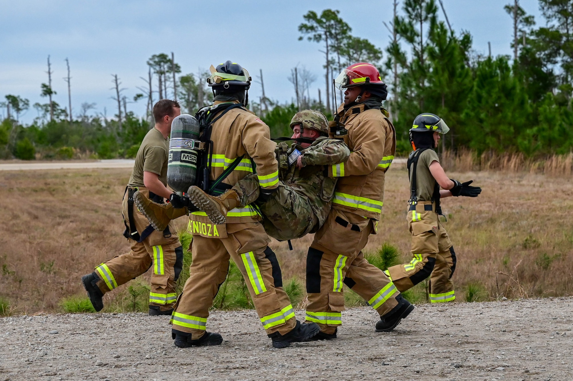 Firefighters carry an injured person.