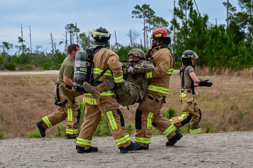 Firefighters carry an injured person.
