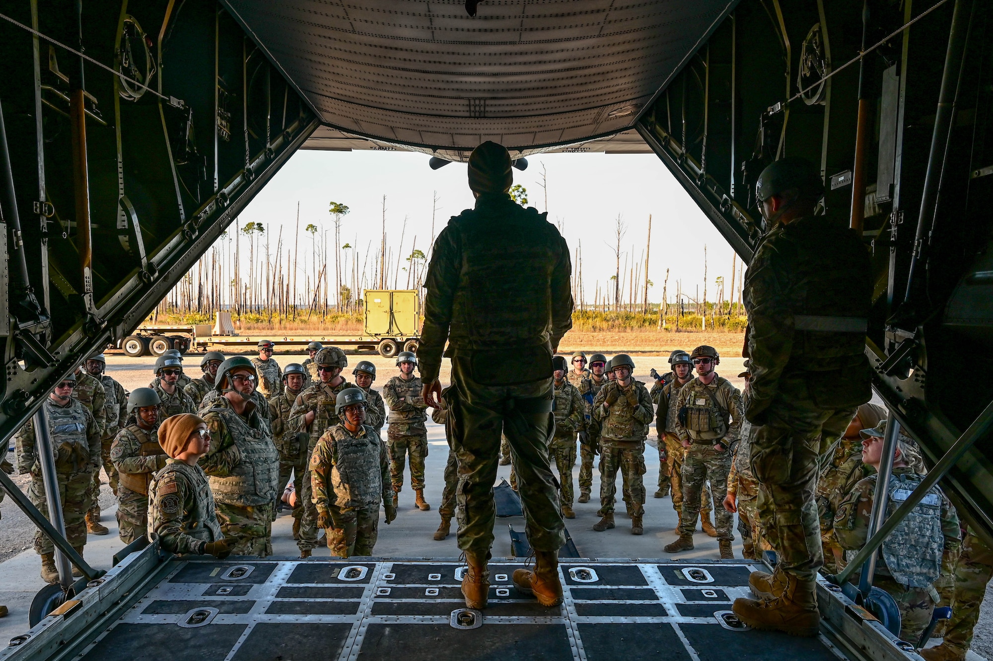 A woman addresses a crowd outside of a plane.