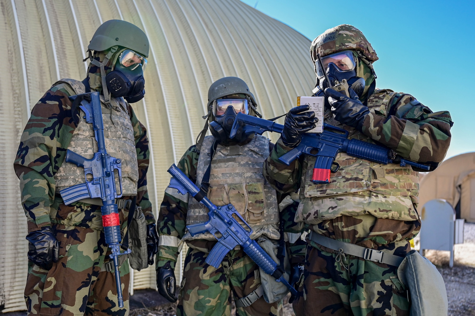 Three guys are dressed in MOP gear speaking on the radio.