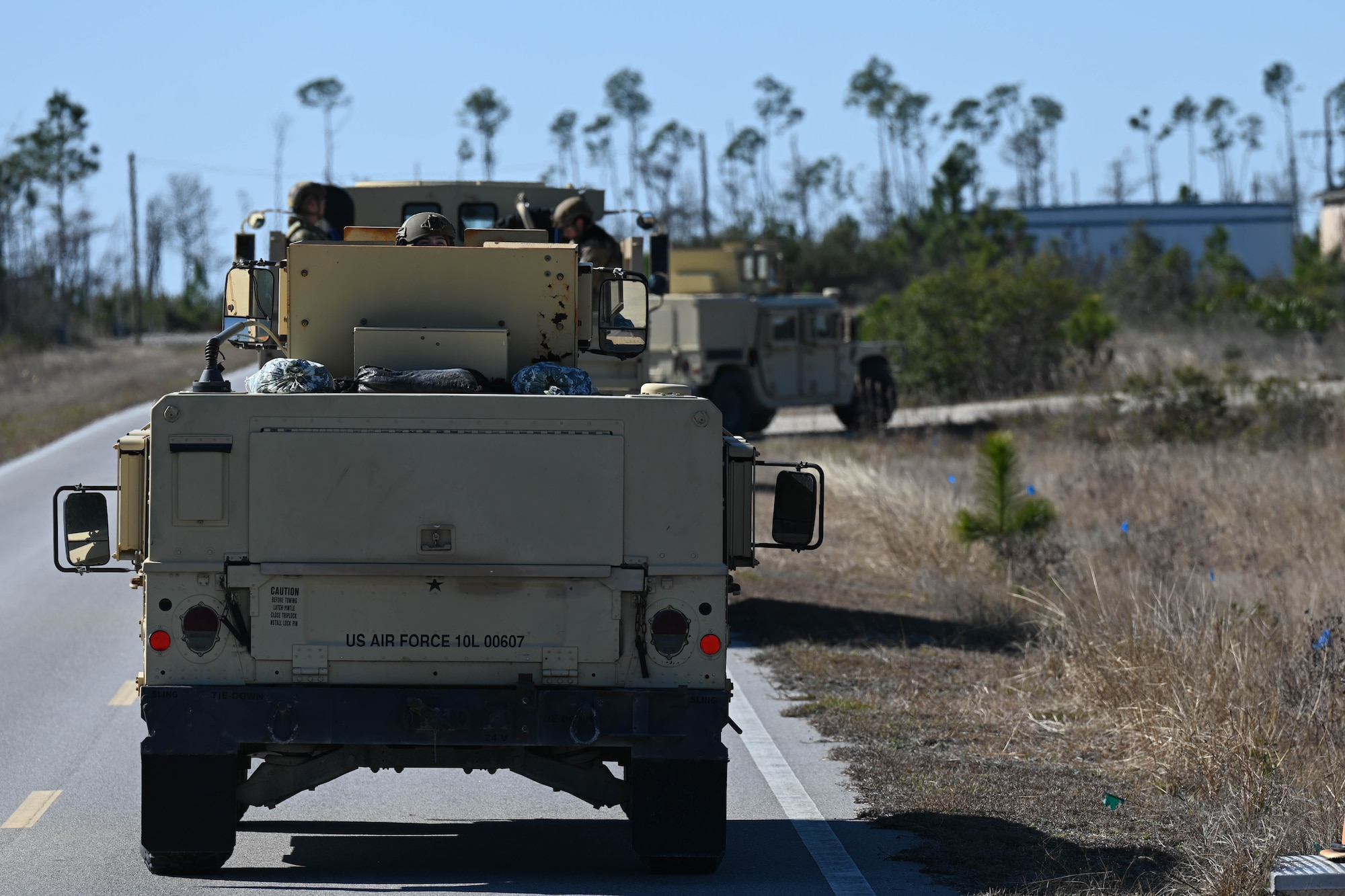 An Airman sticks her head out the top of a humvee.