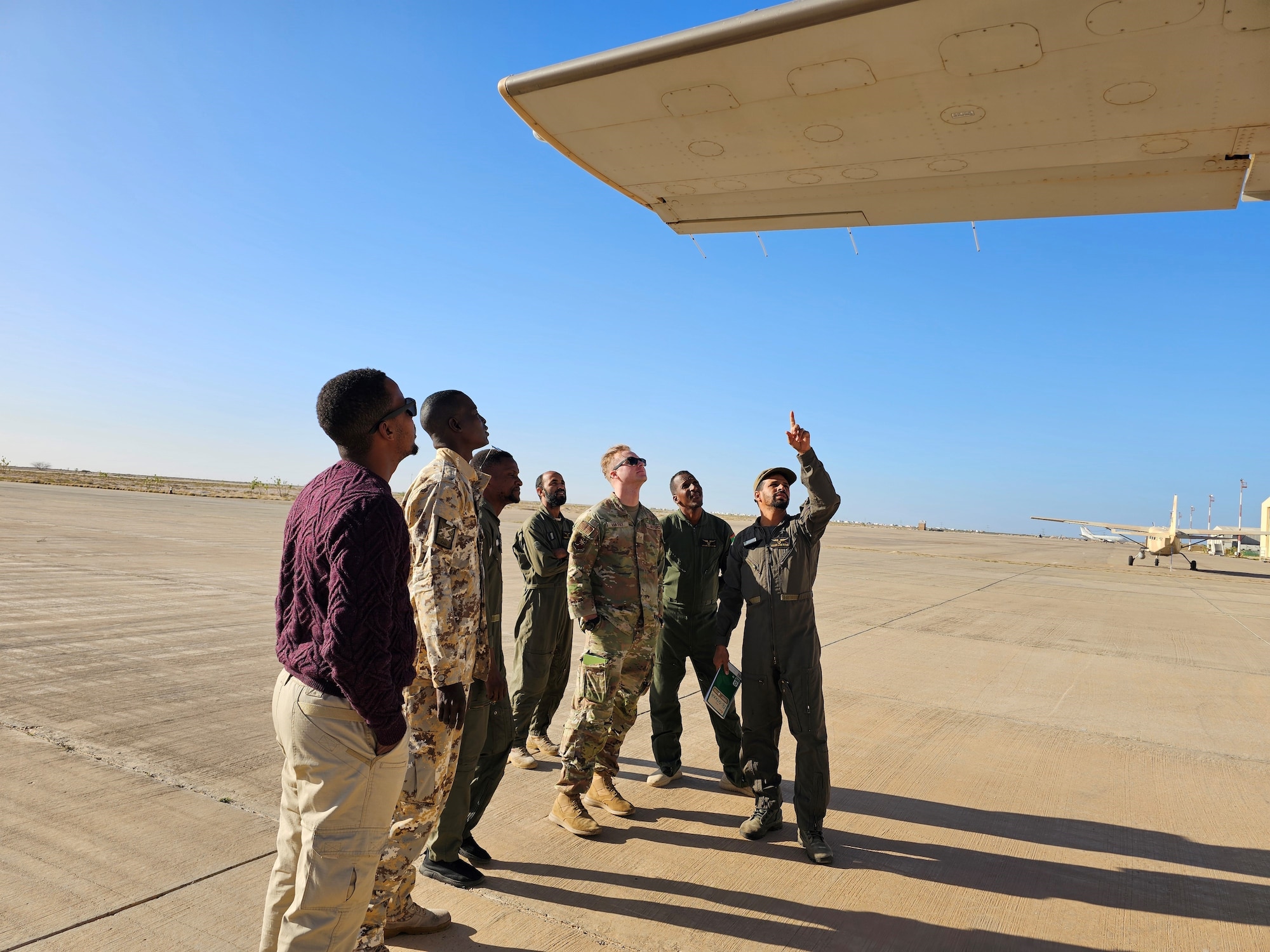 A group of military members pose for a photo in front of a building.