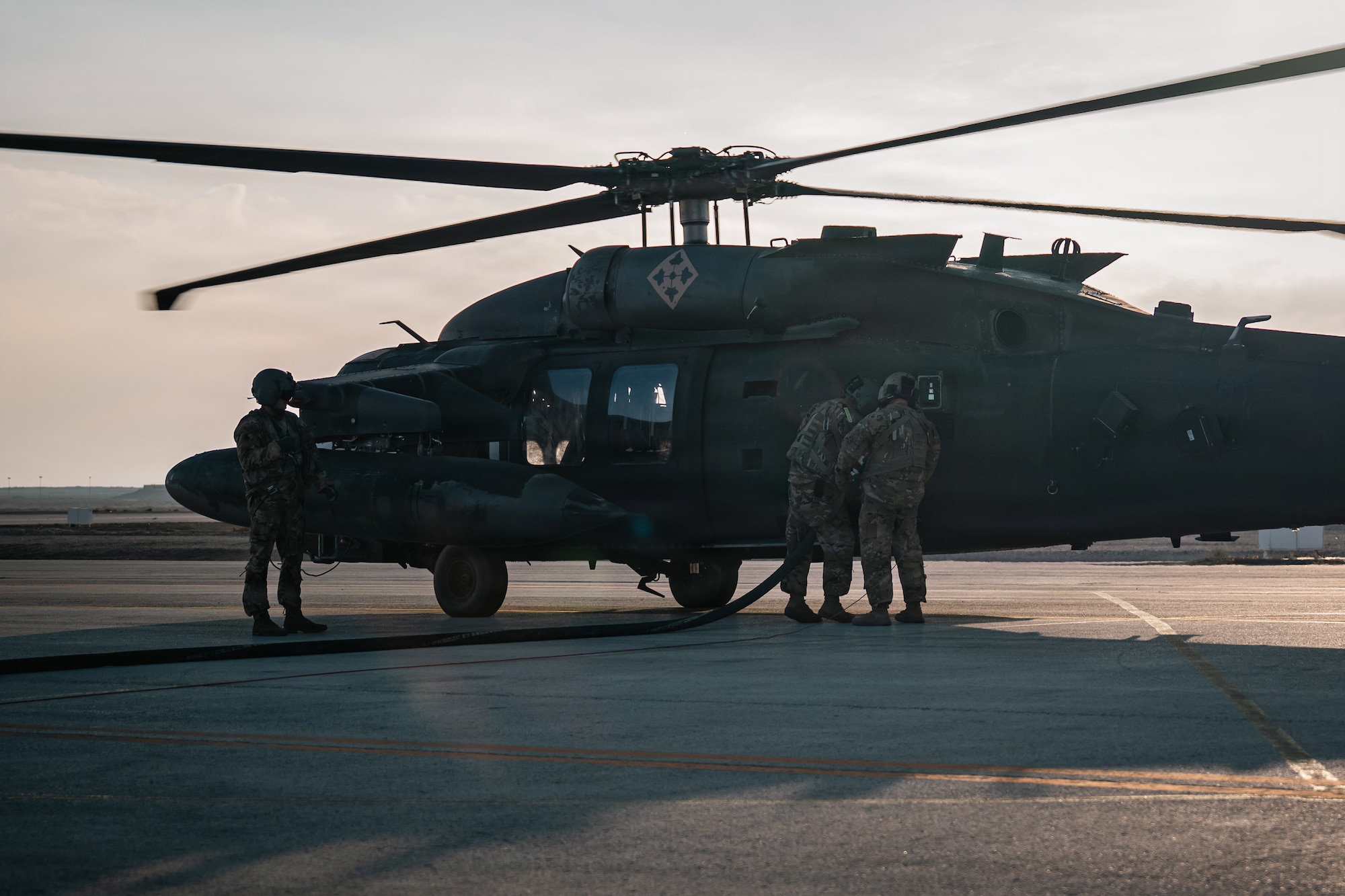U.S. Army Soldiers attach a fuel hose to a UH-60 Black Hawk helicopter on a flightline in the U.S. Central Command area of responsibility, Dec. 14, 2025.