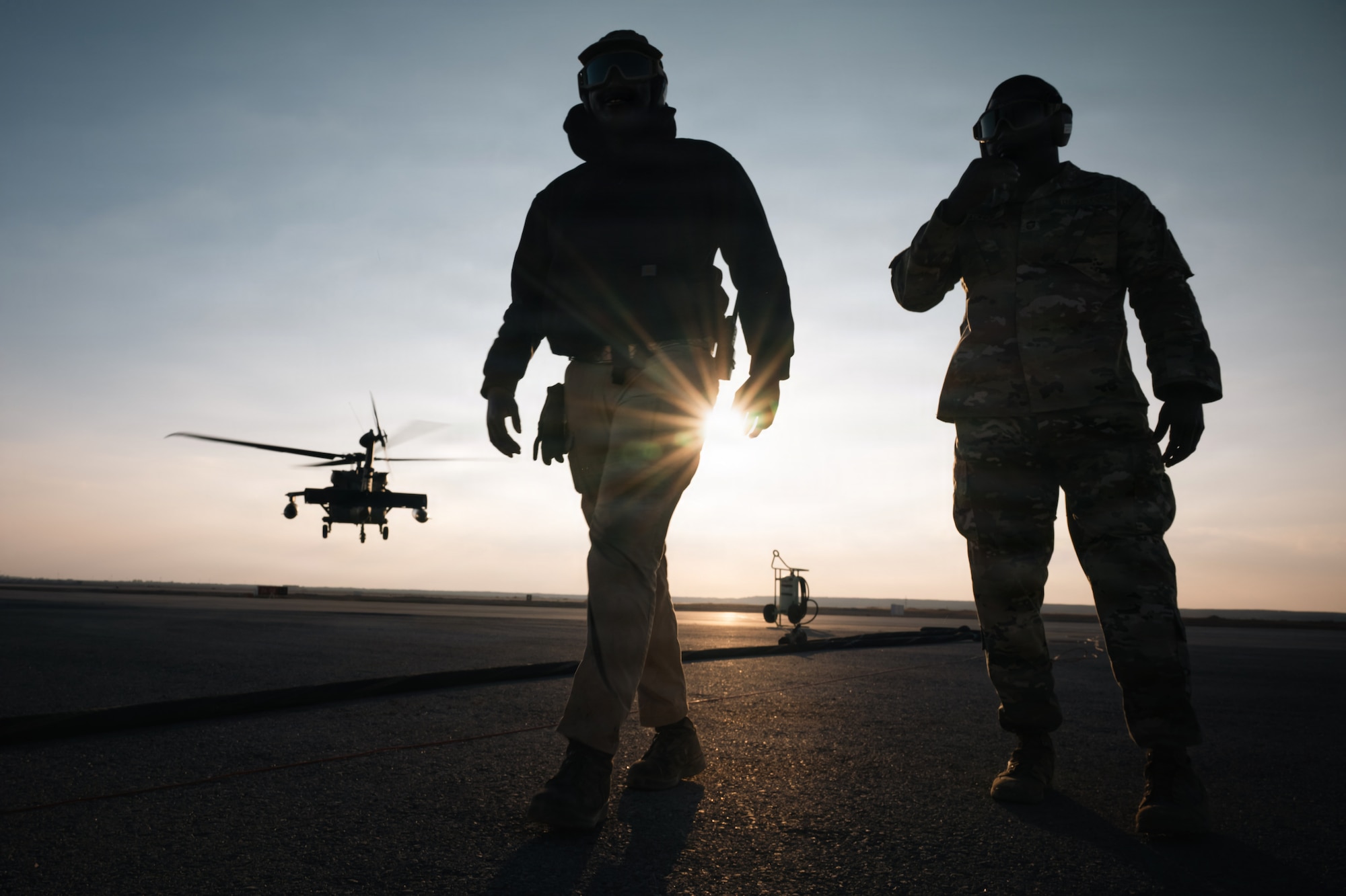 U.S. Air Force Chief Master Sgt. Nicholas Jackson, 332nd Expeditionary Air Base Group senior enlisted leader, right, and Airman 1st Class Samuel Ilet, 332nd Expeditionary Logistics Readiness Squadron fuels distribution operator, walk away as a U.S. Army UH-60 Black Hawk Helicopter takes off in the U.S. Central Command area of responsibility, Dec. 14, 2025.
