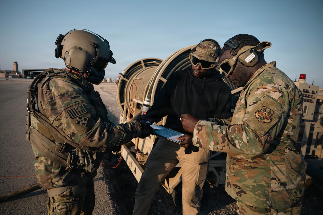 U.S. Air Force Chief Master Sgt. Nicholas Jackson, 332nd Expeditionary Air Base Group senior enlisted leader, right, and Airman 1st Class Samuel Ilet, 332nd Expeditionary Logistics Readiness Squadron fuels distribution operator, center, complete refueling documentation for a U.S. Army aircrew member in the U.S. Central Command area of responsibility, Dec. 14, 2025.