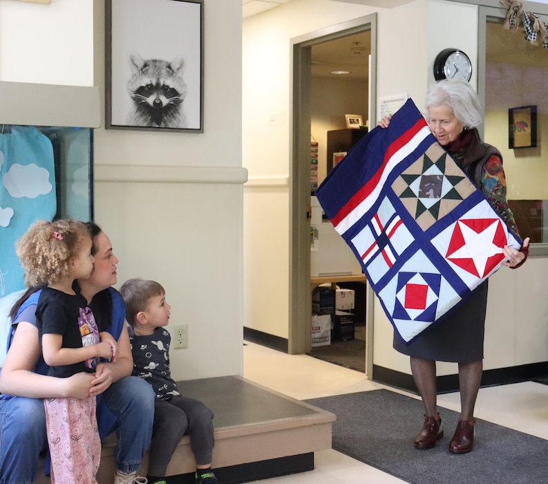 Image of woman donating quilt
