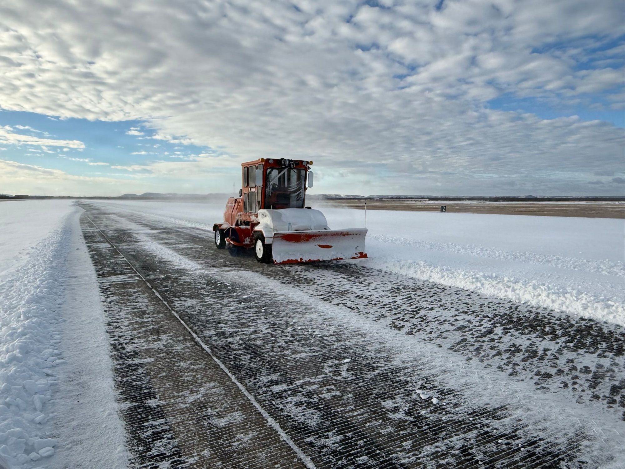 A U.S. Airman assigned to the 7th Civil Engineer Squadron removes ice from the runway during Winter Storm Fern at Dyess Air Force Base, Texas, Jan. 25, 2026. Historically, conditions like this at Dyess lead to waiting for solar melt rather than manual removal, but the 7th CES adapted operations to restore access and set conditions for airfield recovery during the 7th Bomb Wing’s Combat Readiness Exercise. (Courtesy Photo)