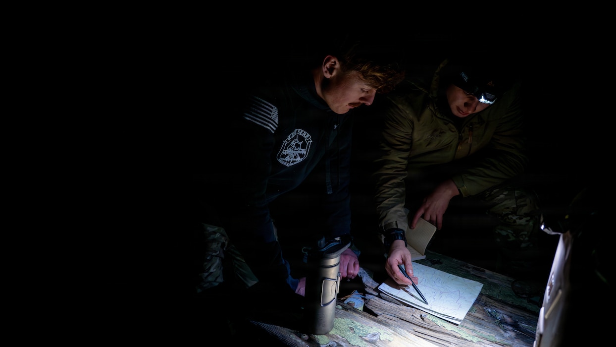 Airmen discuss land navigation routes.