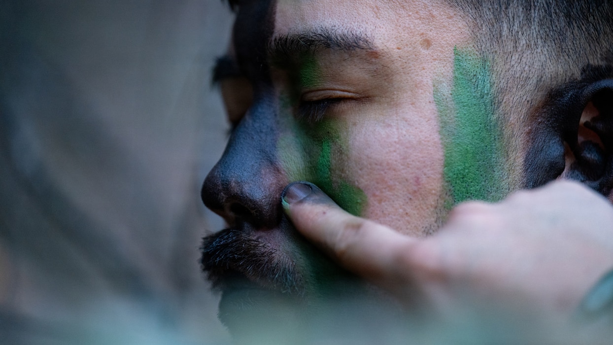 Airman applies camouflage.