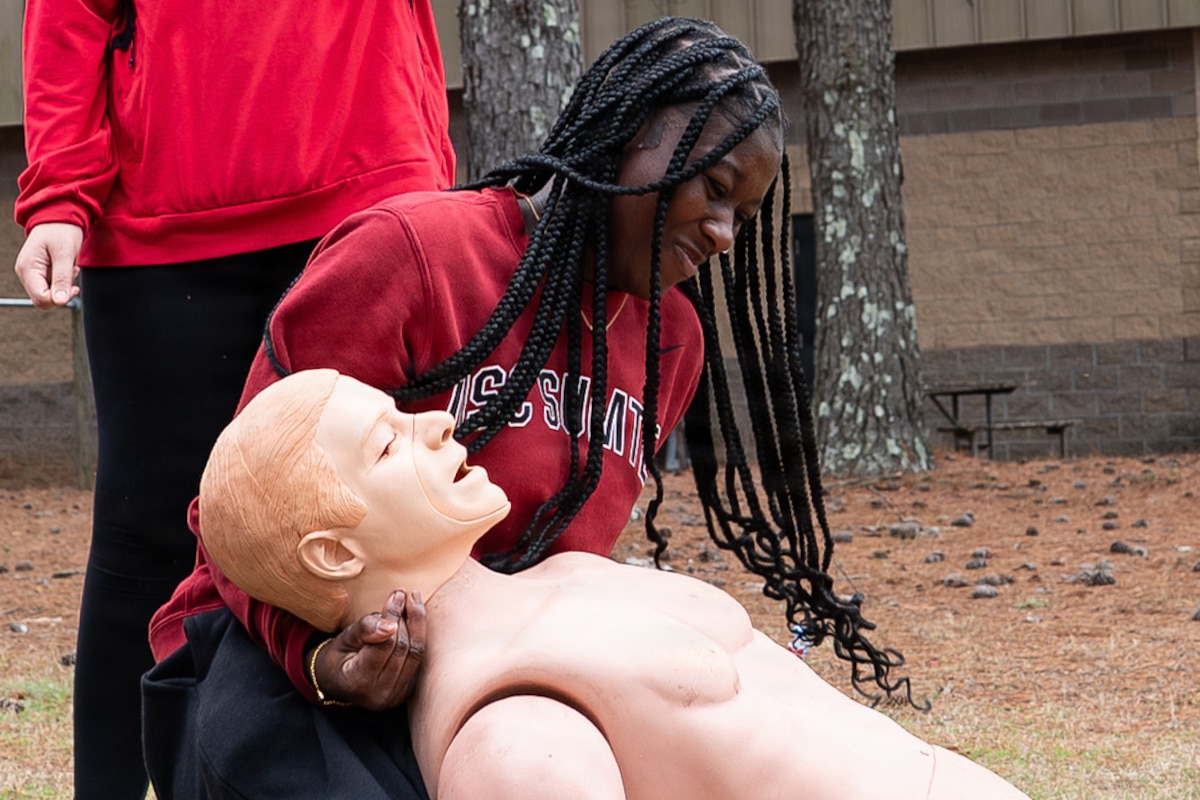 A student lifts the top of a mannequin