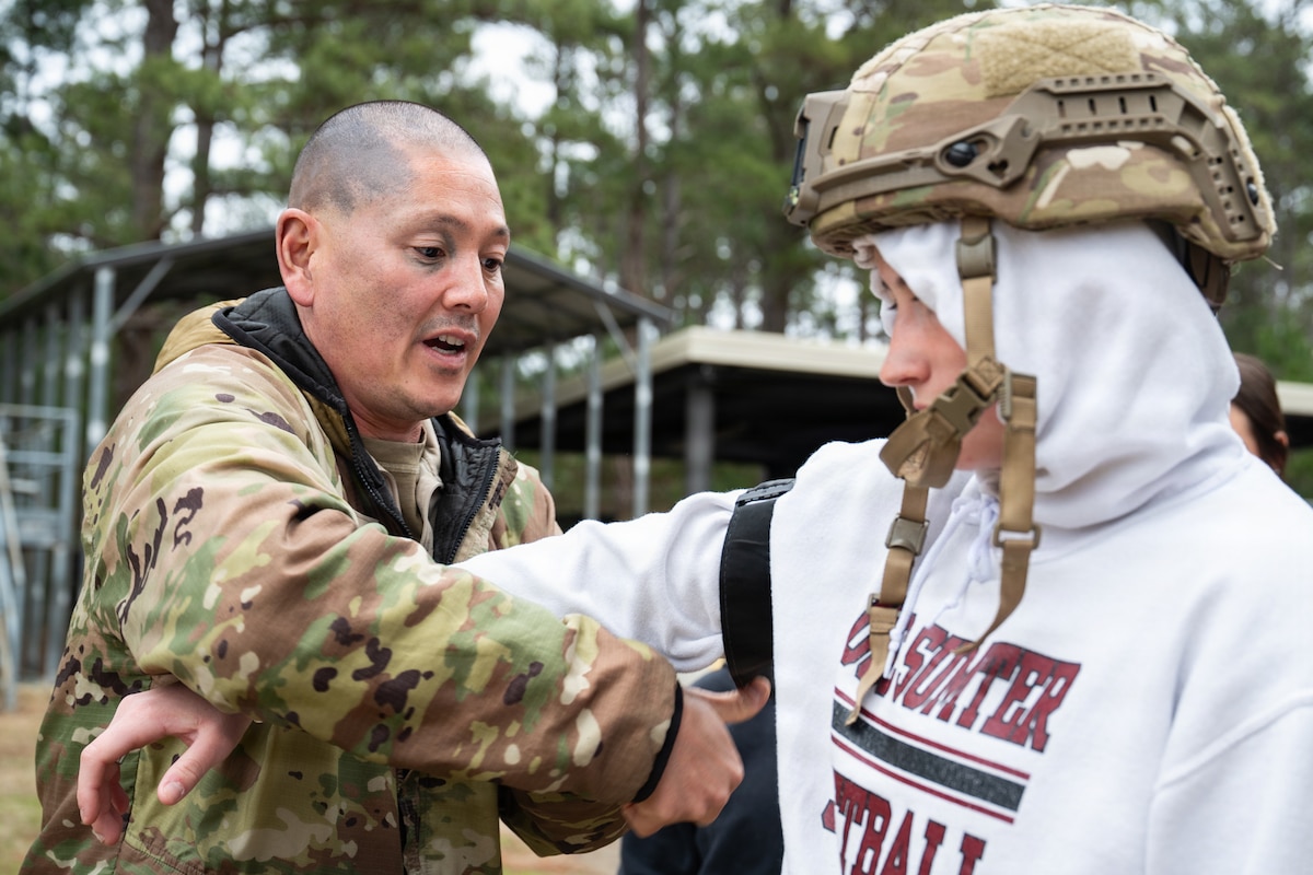 An Airman puts a tourniquet on the arm of a student