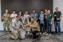 Capt. Ryan McCrillis, commander of the Pearl Harbor Naval Shipyard and Intermediate Maintenance Facility, poses with University of Hawaii Manoa students following their final presentations on Dec. 5, 2025.